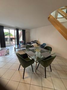 a dining room with a glass table and green chairs at Bella vista in Marklkofen