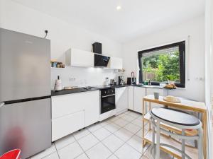 a kitchen with white cabinets and a table and a window at "Smart Studio" I Die Hotel Alternative - mehr Freiraum auf 50qm plus Gartenterrasse in Haselünne