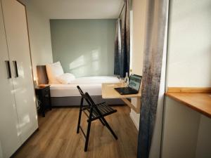 a small room with a bed and a desk with a laptop at Gästehaus im Schlosspark in Saffig +10 photos