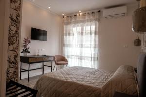 a bedroom with a bed and a desk and a window at La Vecchia Taverna - Hotel Restaurant Catering in Oliveto Citra