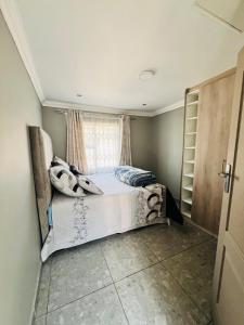 a bedroom with a bed and a window at Affordable Modern Stay in Vanderbijlpark