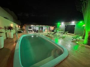 a swimming pool at night with a patio at Casa para eventos e acomodações in Goiânia