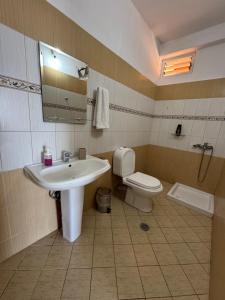 a bathroom with a sink and a toilet and a mirror at k&k apartament in Sarandë