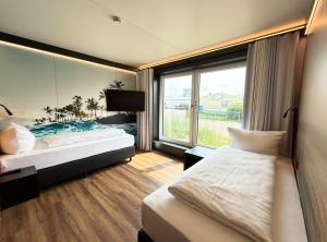 a bedroom with two beds and a large window at WEN Hotel by WMM Hotels in Weiden