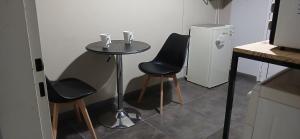 a small table with two chairs and a small refrigerator at aleyluna in Berrotarán