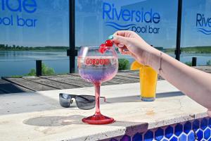 a woman is holding a cherry in a wine glass at Danubius View - Luxury Hotel and Hall in Kozloduy