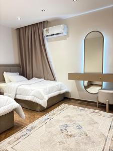 a bedroom with two beds and a mirror at شقة على النيل مطله على ممشى اهل مصر in Cairo