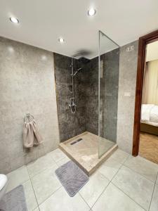 a bathroom with a shower with a glass shower stall at شقة على النيل مطله على ممشى اهل مصر in Cairo +26 photos