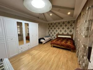 a large bedroom with a bed and a large mirror at Home in Gabala
