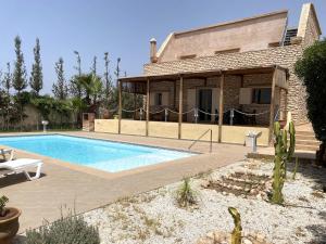a villa with a swimming pool in front of a house at Dar Chams-Villa Essaouira 3 chambres in Essaouira