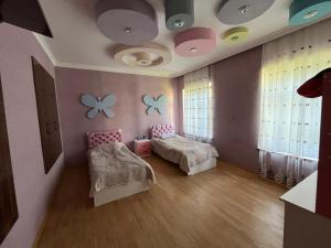 a room with two beds and butterflies on the ceiling at Home in Gabala