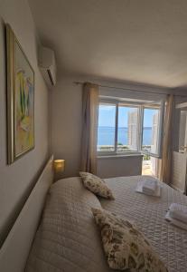 a bedroom with a bed with a view of the ocean at Apartments Lusi in Brela