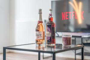 two bottles of wine and a glass on a table at Luxury Wembley Apt - 9 guests! in London