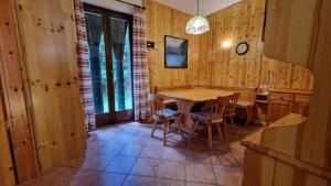 a dining room with a wooden table and chairs at Lavarone & Folgaria Residence in Lavarone +15 photos