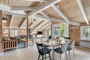 a dining room and living room with a table and chairs at BL1052-Blokhus-Berberisvej-22 in Blokhus