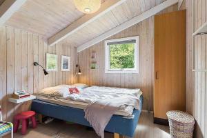 a bedroom with a bed in a wooden wall at BL1052-Blokhus-Berberisvej-22 in Blokhus
