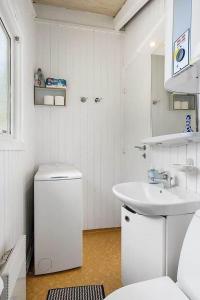 a white bathroom with a sink and a toilet at BL1052-Blokhus-Berberisvej-22 in Blokhus +20 photos