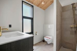 Un baño con lavabo, inodoro y ventana. en BL1436-Blokhus-Mollevej-13, en Blokhus 19 fotos más