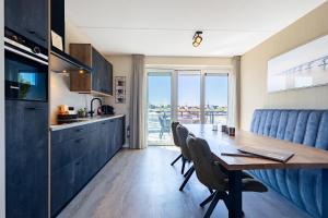 a kitchen and dining room with a table and chairs at Vakantiewoning aan het strand 'Somaris' - met tuin en terras - Vista Maris - Nr 50 in Sint Annaland