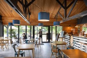 ein Restaurant mit Holzdecken und Tischen und Stühlen in der Unterkunft Huttopia Baie du Mont Saint Michel in Baguer-Pican