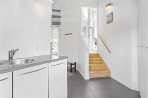 una cucina bianca con lavandino e scala di BL1555-Blokhus-Egebaeksvej-17 a Blokhus Altre 21 foto