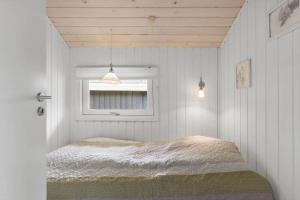 a bedroom with a bed and a window at BL1739-Blokhus-Bag-Hojen-47 in Blokhus
