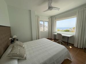 una camera da letto con un letto, una scrivania e una finestra di Atalaya Blanca a San José