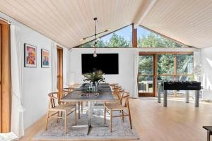 布洛克胡斯BL1718-Blokhus-Ronliensvej-16的一间带桌子和钢琴的用餐室