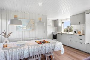 a white kitchen with a table with chairs and a table and a tableweredktop at BL1326-Saltum-Svendborgvej-19 in Saltum