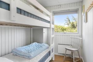 a small bedroom with a bunk bed and a chair at BL1326-Saltum-Svendborgvej-19 in Saltum