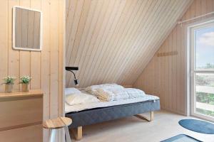 una camera da letto con un letto nell'angolo di una stanza di BL381-Blokhus-Maxvej-4 a Blokhus