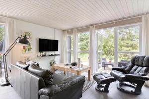 un soggiorno con sedie in pelle e una televisione di BL381-Blokhus-Maxvej-4 a Blokhus