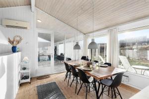 a dining room with a wooden table and chairs at BL738-Saltum-Graabakken-53 in Saltum
