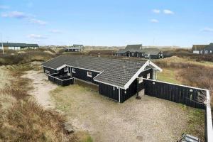 a house with a black roof on a beach at BL738-Saltum-Graabakken-53 in Saltum