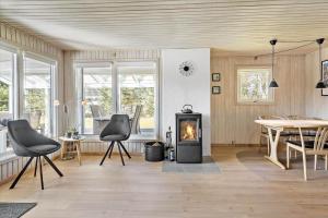 a living room with a fireplace and a table and chairs at BL1361-Saltum-Jaerens-Rev-Sydvest-8 in Saltum