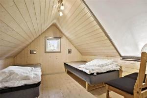 una camera con due letti e una sedia in mansarda di BL238-Pandrup-Fyrregangen-18 a Pandrup