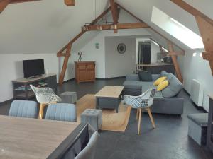 a living room with a couch and a table and chairs at La Voilerie in Fécamp