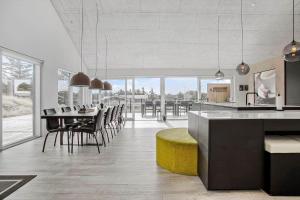 eine Küche und ein Esszimmer mit Tisch und Stühlen in der Unterkunft BL1405 Blokhus - Sletten 12 in Blokhus