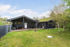 una casa negra con terraza y patio en BL1505-Pandrup-Skorr-Karensvej-3, en Pandrup