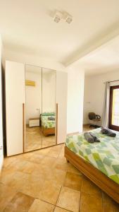 a bedroom with a bed and a mirror at Casa IXI in Santadi