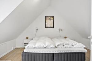 a bed in a room with white walls at BL1260-Blokhus-Strandvejen-14-Lejl-9 in Blokhus