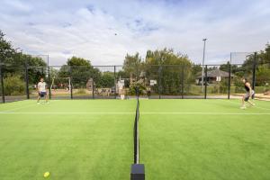 zwei Personen, die Tennis auf einem Tennisplatz spielen in der Unterkunft Huttopia Baie du Mont Saint Michel in Baguer-Pican