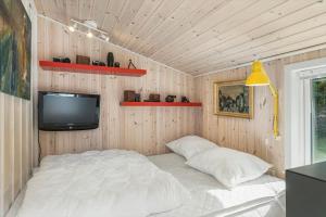 a bedroom with a bed and a tv on the wall at BL1466-Pandrup-Lunekrogen-14 in Pandrup