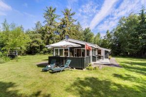 a gazebo with chairs and an umbrella in a yard at BL1466-Pandrup-Lunekrogen-14 in Pandrup
