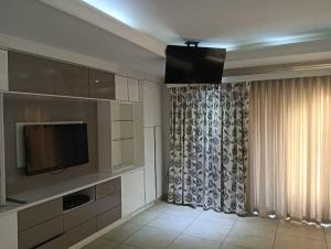 a living room with a television and a curtain at One Seven One in Klerksdorp