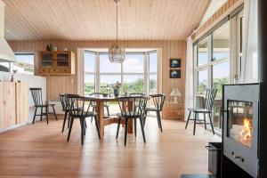 a dining room with a table and chairs and a fireplace at BL1399-Saltum-Laustvej-30 in Saltum