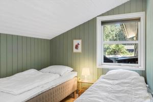 two beds in a room with a window at BL1399-Saltum-Laustvej-30 in Saltum