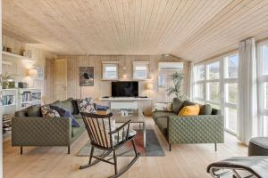 uma sala de estar com um sofá e uma mesa em BL709-Blokhus-Kr-Thomsensvej-5 em Blokhus