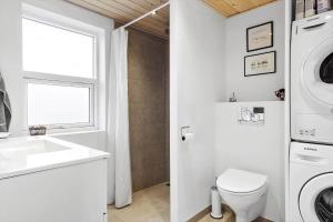 uma casa de banho com um lavatório e uma máquina de lavar roupa em BL709-Blokhus-Kr-Thomsensvej-5 em Blokhus mais 20 fotografias