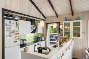 a kitchen with white cabinets and a white refrigerator at BL1666-Saltum-Vikingebanke-5 in Saltum +24 photos
